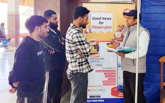 Railway staff helping passengers to download and install ‘RailOne’ app on their mobile phones during awareness campaign.