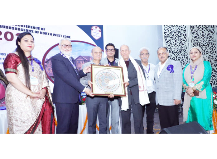 Principal GMC Jammu Dr Ashutosh Gupta along with other dignitaries presenting an award to a senior doctor during a conference.