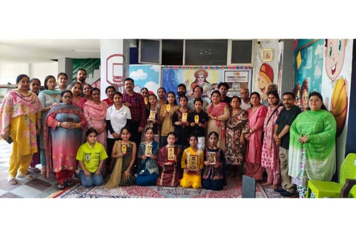 Students and others posing for a group photograph during a children's Dogri dance festival in Jammu on Saturday.