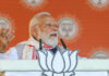 Prime Minister Narendra Modi addresses the public meeting in Barpeta, Assam on Monday. (UNI)