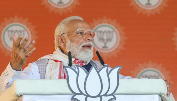Prime Minister Narendra Modi addresses the public meeting in Barpeta, Assam on Monday. (UNI)