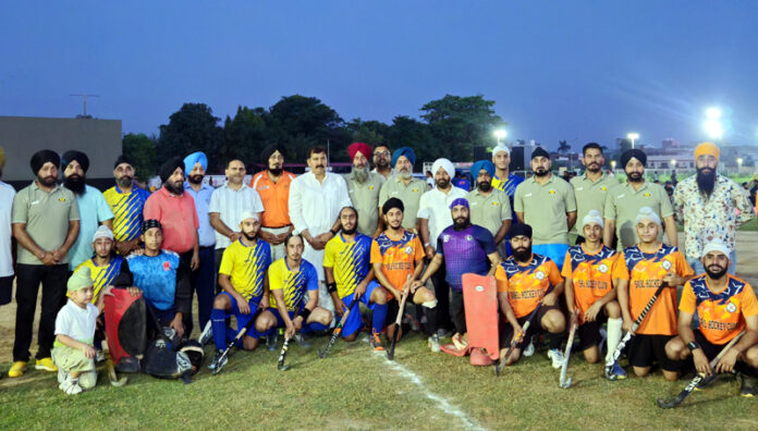 Hockey players posing along with dignitaries during a programme.