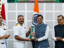 Principal, Captain (IN) Shibu Devasia receiving trophy from Minister of State for Defence Sanjay Seth in a programme.