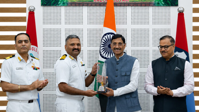 Principal, Captain (IN) Shibu Devasia receiving trophy from Minister of State for Defence Sanjay Seth in a programme.