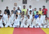 Athletes posing for a group photograph along with dignitaries.