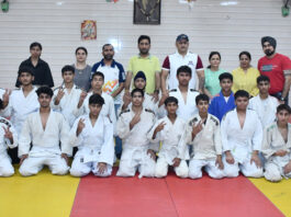 Athletes posing for a group photograph along with dignitaries.