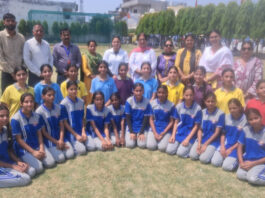 Girls posing for group photograph along with dignitaries during an event.