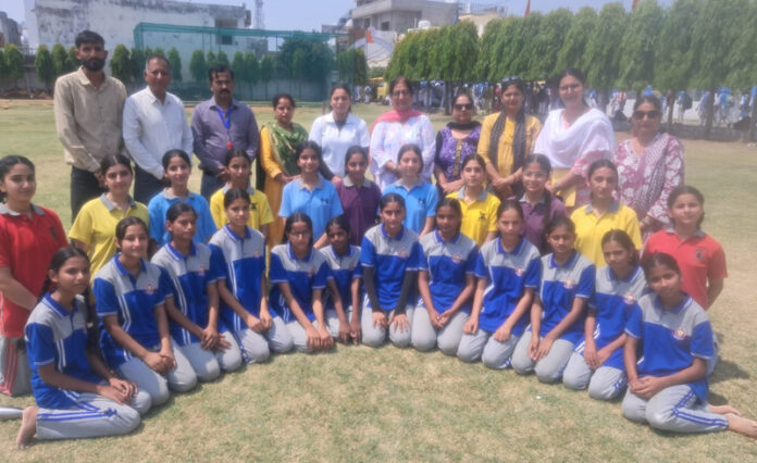 Girls posing for group photograph along with dignitaries during an event.