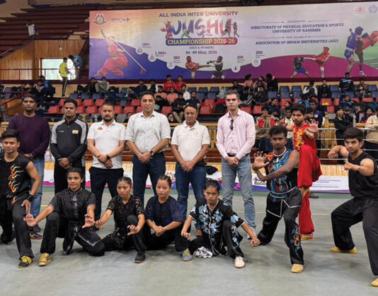 Dignitaries posing along with Wushu players during an event.