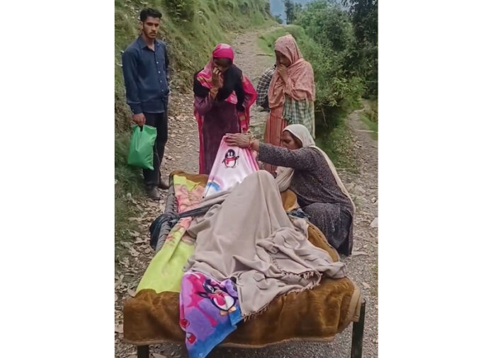 An ailing villager being shifted on cot to Budhal hospital. -Excelsior/Imran