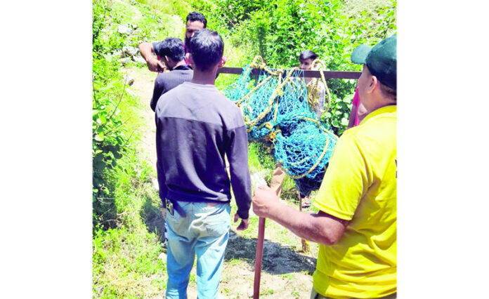 Personnel of Wildlife Protection Department taking away a rescued Asiatic Black Bear in Doda on Sunday. -Excelsior/Tilak Raj