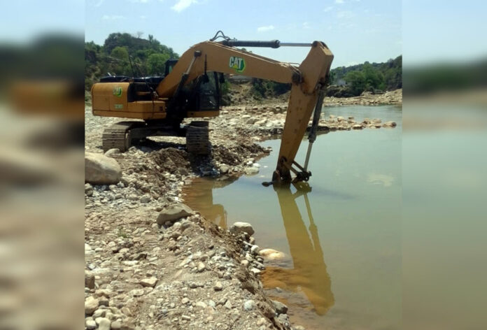 A heavy machine operating near a stone crusher in Jhajjar Nallah at Dansal.