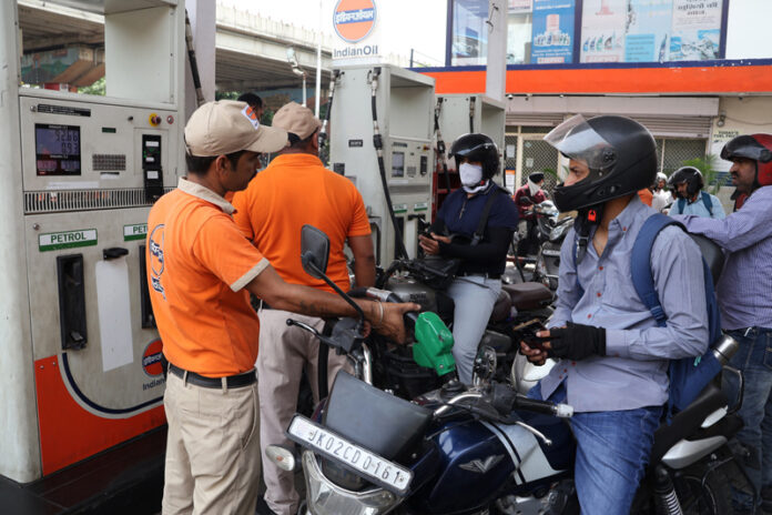Commuters at a petrol pump in Jammu on Friday. (UNI)