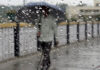 A man walks with umbrella cover during rain in Jammu on Saturday. Another pic on page 4. — Excelsior/Rakesh
