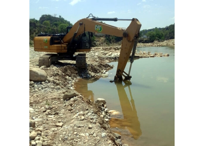 A heavy machine operating near a stone crusher in Jhajjar Nallah at Dansal.