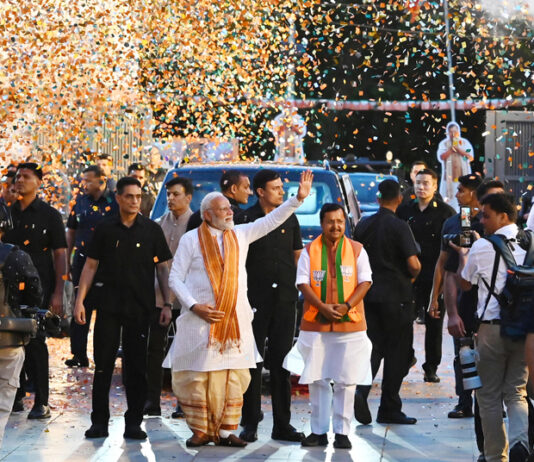Prime Minister Narendra Modi greets his supporters as he arrives at the BJP headquarters in New Delhi on Monday. (UNI)