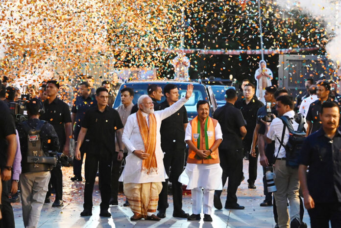 Prime Minister Narendra Modi greets his supporters as he arrives at the BJP headquarters in New Delhi on Monday. (UNI)