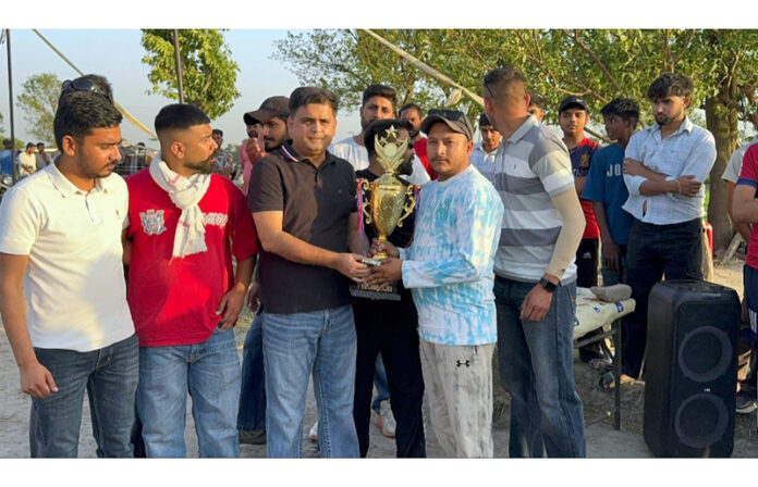 Congress leader Neeraj Kundan presenting title trophy to captain of Dablehar team.