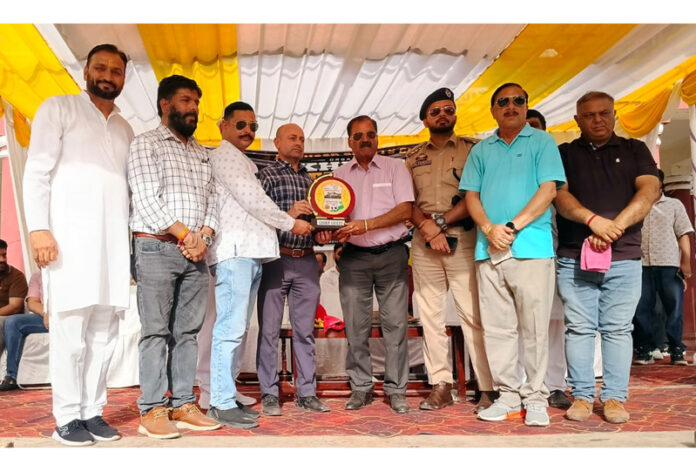 Organizers presenting a memento to the chief guest during semifinals of the Akhnoor Football Cup.