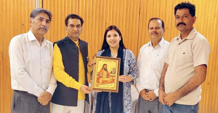 Balbir Ram Rattan, BJP spokesperson presenting portrait of Guru Ravi Dass to MLA Nagrota Devyani Rana at Jammu on Thursday. Balbir Ram Rattan, BJP spokesperson presenting portrait of Guru Ravi Dass to MLA Nagrota Devyani Rana at Jammu on Thursday.