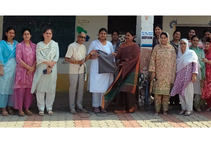 Social activist Kewal Wadhera posing with teachers at GHSS Bahu Fort in Jammu.