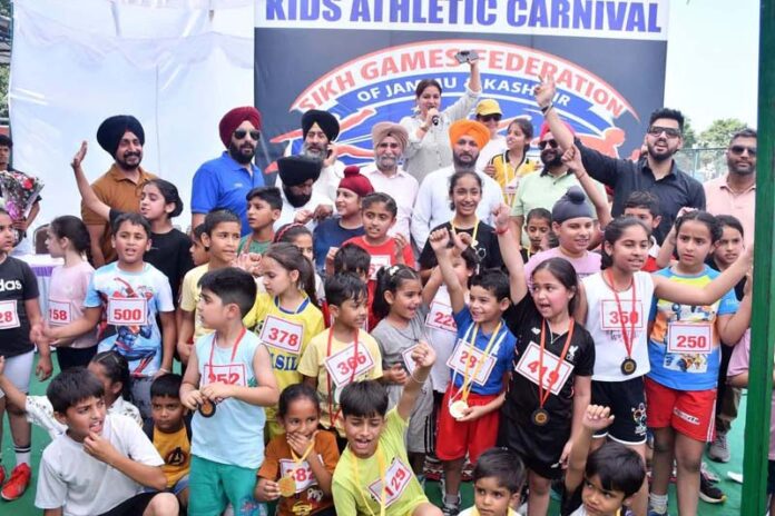 Dignitaries posing along with young athletes during a programme.