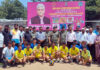 Dignitaries posing along with athletes during a programme.