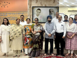 Participants posing for a group photograph along with dignitaries during a programme.