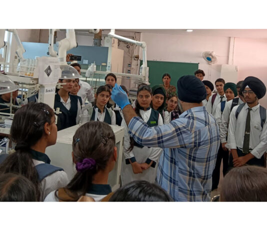 An expert demonstrating scientific experiments to students during their educational visit to IIT Jammu.