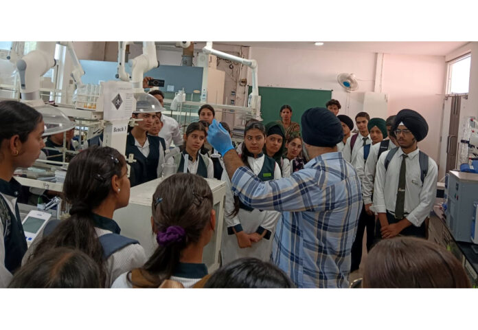 An expert demonstrating scientific experiments to students during their educational visit to IIT Jammu.