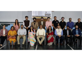 Dignitaries posing along with participants from different Universities during an event.