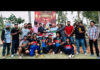 Winning team posing along with trophy.