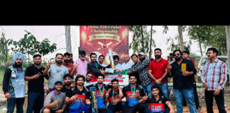 Winning team posing along with trophy.