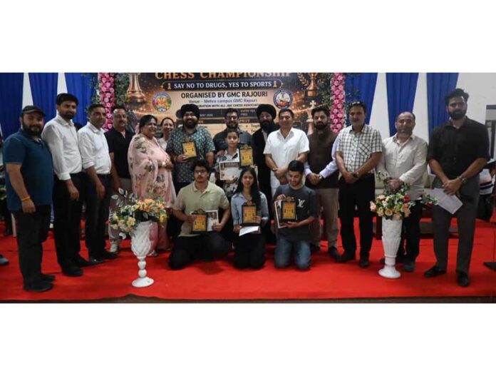 Chess players posing along with certificates during a programme.