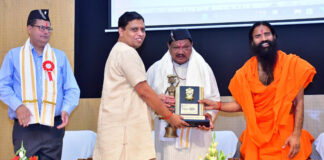 Swami Ramdev and Acharya Balkrishan of Patanjali Yogpeeth presenting a memento to Union Minister for Tribal Affairs, Jual Oram during an event in Haridwar on Thursday.
