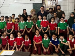 Dignitaries posing with young participants during the programme.
