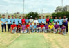 Players posing along with dignitaries during an event.
