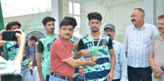Dignitary presenting medal to players during a programme.