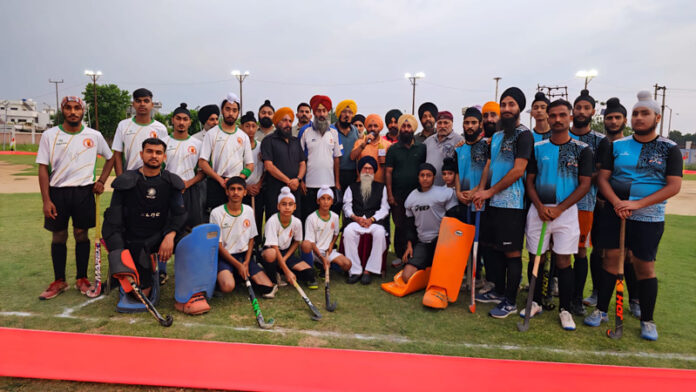 Hockey players posing along with dignitaries for photograph.