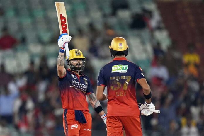 Virat Kohli raising his bat after scoring an unbeaten 105 runs against KKR in Raipur.