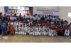 Karate players posing along with dignitaries during an event.