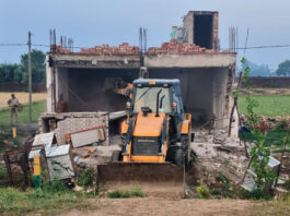 An illegal structure being demolished at Chak Avtara area in Bishnah town on Monday.