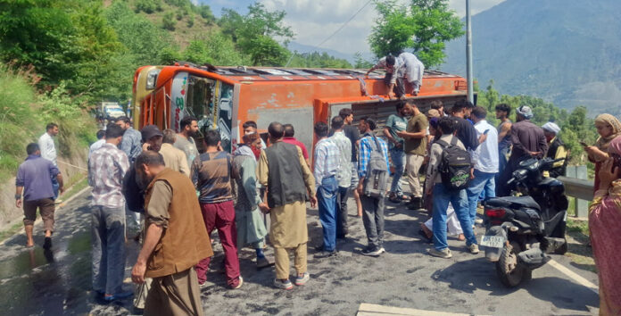 Rescuers and locals gathering near the bus which overturned along Gool-Ramban road on Tuesday. —Excelsior/Pervaiz Mir Rescuers and locals gathering near the bus which overturned along Gool-Ramban road on Tuesday. —Excelsior/Pervaiz Mir