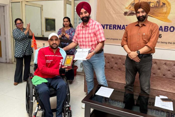 Labour Commissioner J&K, Charandeep Singh felicitating a worker for his invaluable contribution during a function in Jammu.