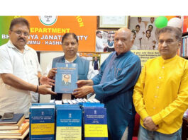 BJP J&K UT president and MP, Sat Sharma receiving books on Dr Ambedkar from party vice president, Bharat Bushan at Jammu on Sunday.