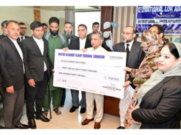 Justice Sanjeev Kumar giving claim cheque to a claimant on Saturday.