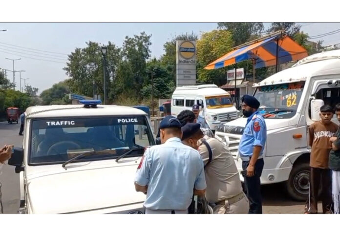Traffic Police personnel challaning a vehicle parked along BC Road in Jammu on Thursday.