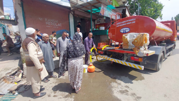 Residents collecting drinking water from a tanker at Safapora on Monday. -Excelsior/Firdous Ahmad.