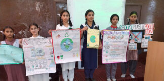 Students posing with posters during a programme.