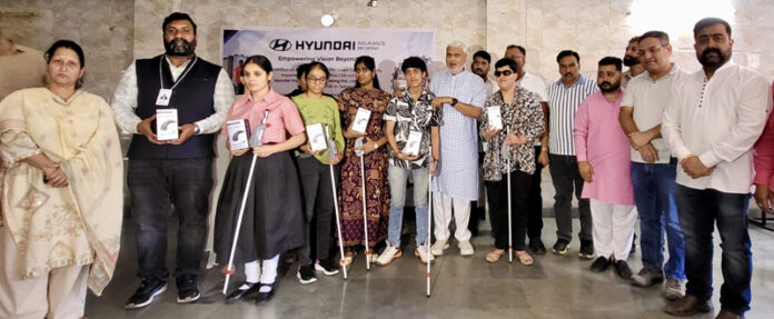 MLA Sham Lal Sharma presenting smart canes to visually impaired persons in Jammu.